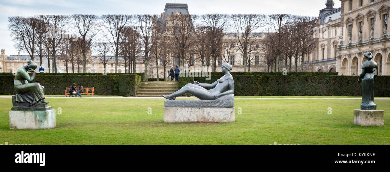 Paris statues of women outside on the grass near the Louvre Museum. Winter scene. Sheared hedges