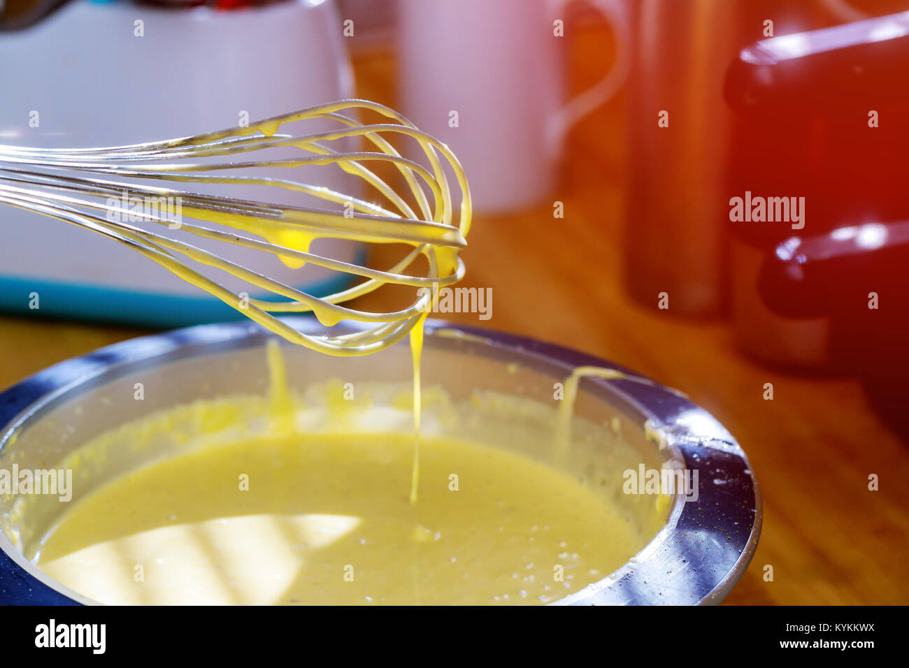 Mixing egg, flour and sugar cream in bowl with motor mixer. Kneaded dough for baking a cake Stock Photo