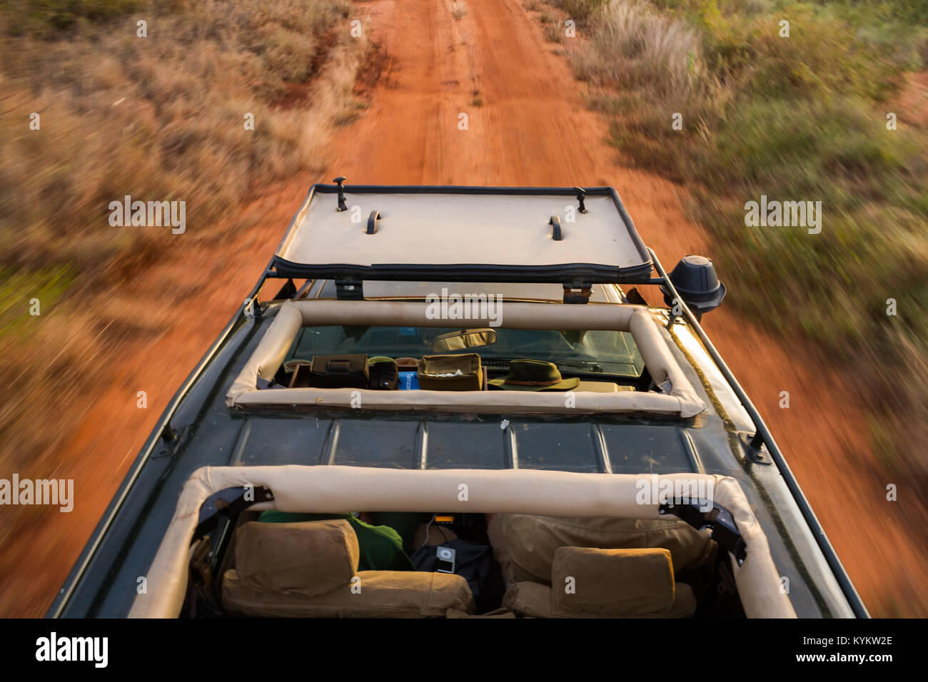 Safari vehicle driving down a dirt road in Serengeti National Park Stock Photo