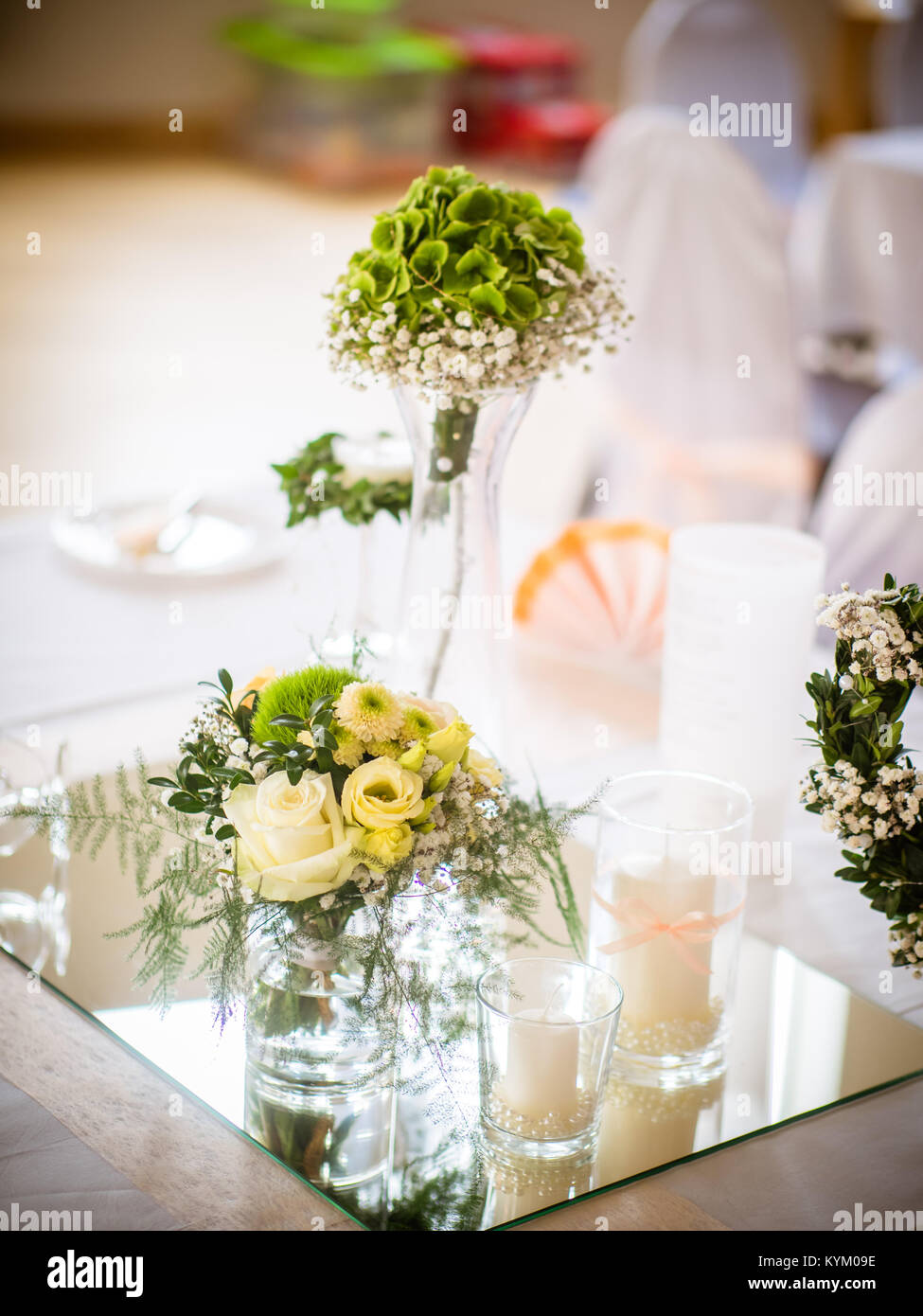 the small table decoration with white roses standing on a small mirror Stock Photo