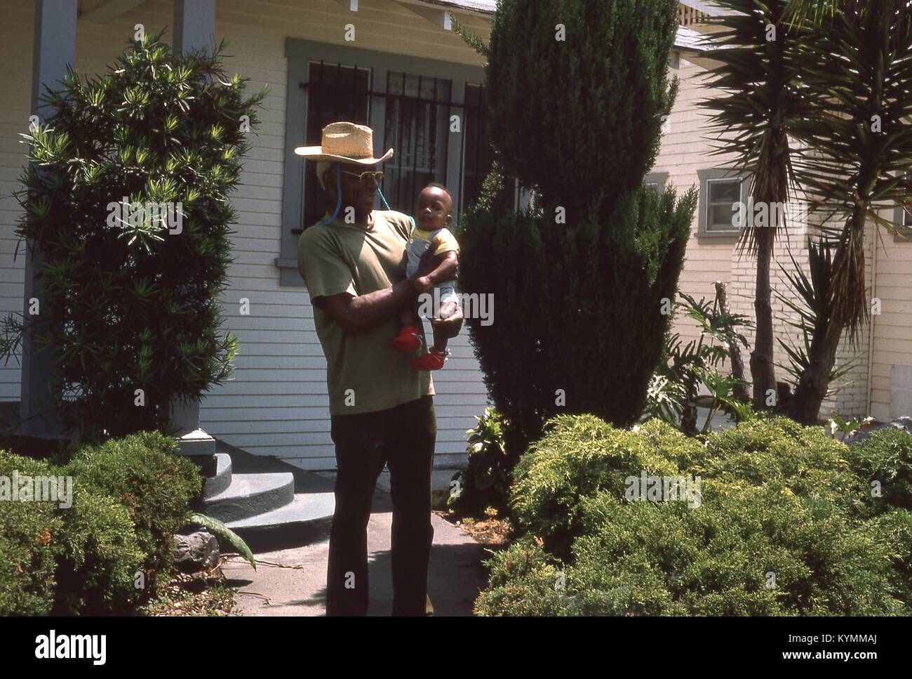 Portrait of a smiling African American man holding an infant African ...