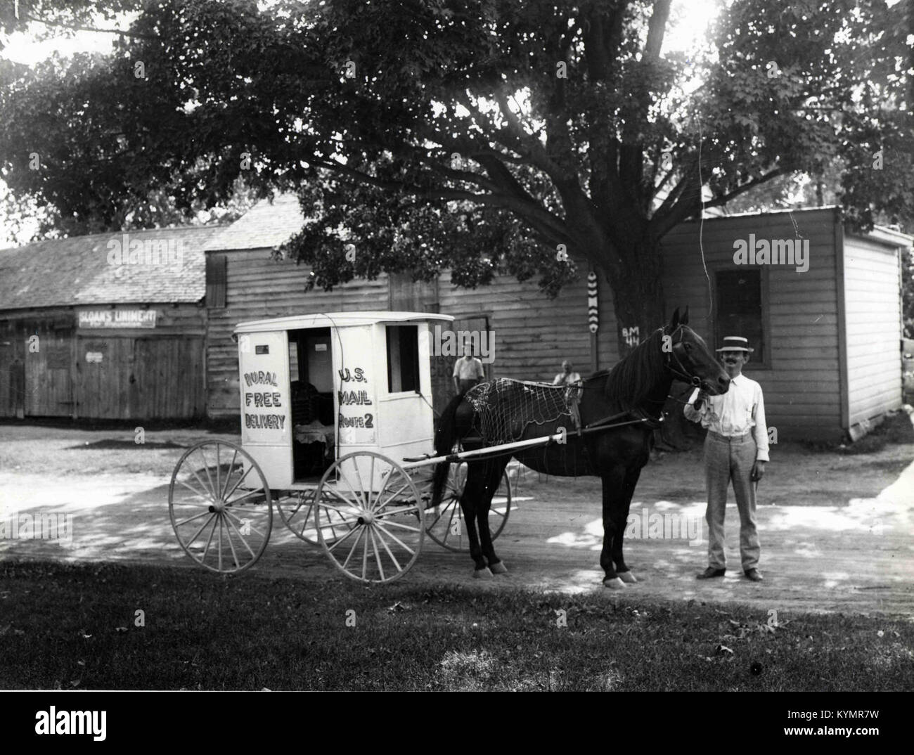 A historic photograph of a Rural Free Delivery carrier with a horse-drawn wagon, part of the U.S. Postal Service’s Rural Free Delivery program, documenting early 20th-century mail delivery in rural America. Stock Photo