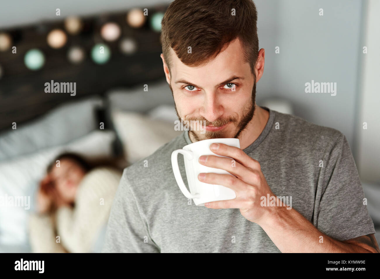Front view of man drinking coffee in bedroom Stock Photo