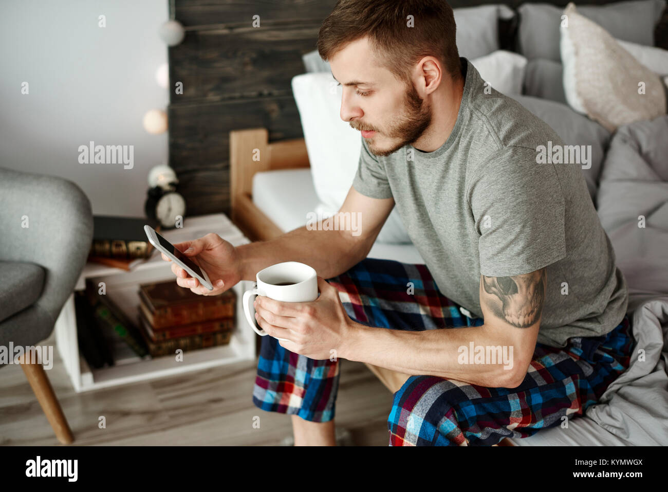 Man with coffee and mobile phone texting Stock Photo