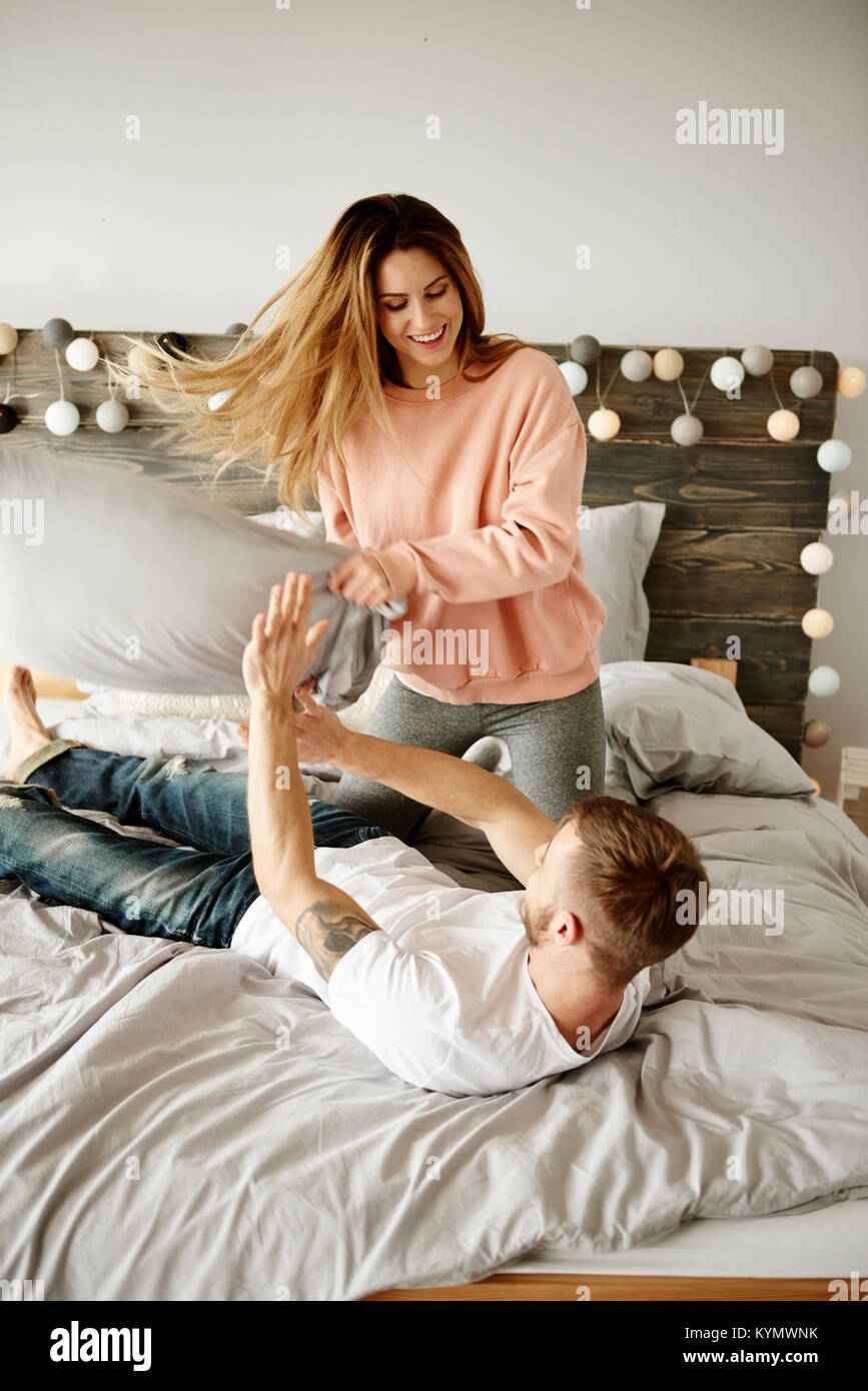 Couple enjoying during pillow fight Stock Photo