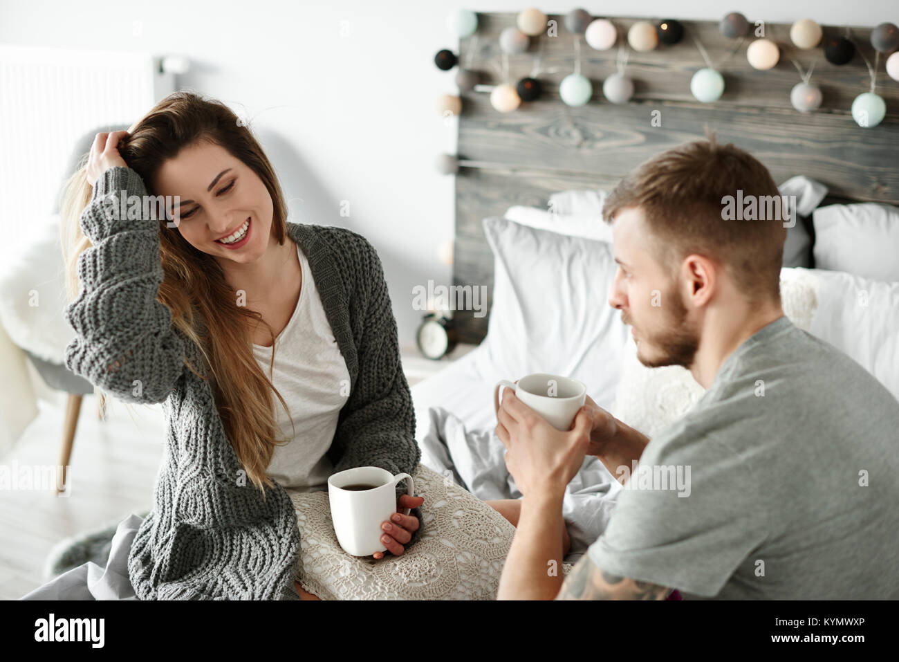 Couple drinking morning coffee at bedroom Stock Photo