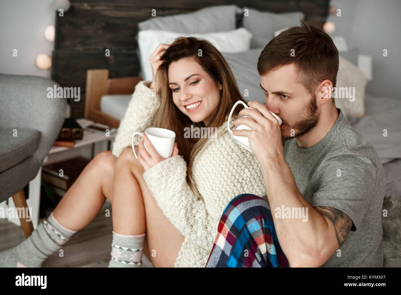 Affectionate couple drinking morning coffee at bedroom Stock Photo