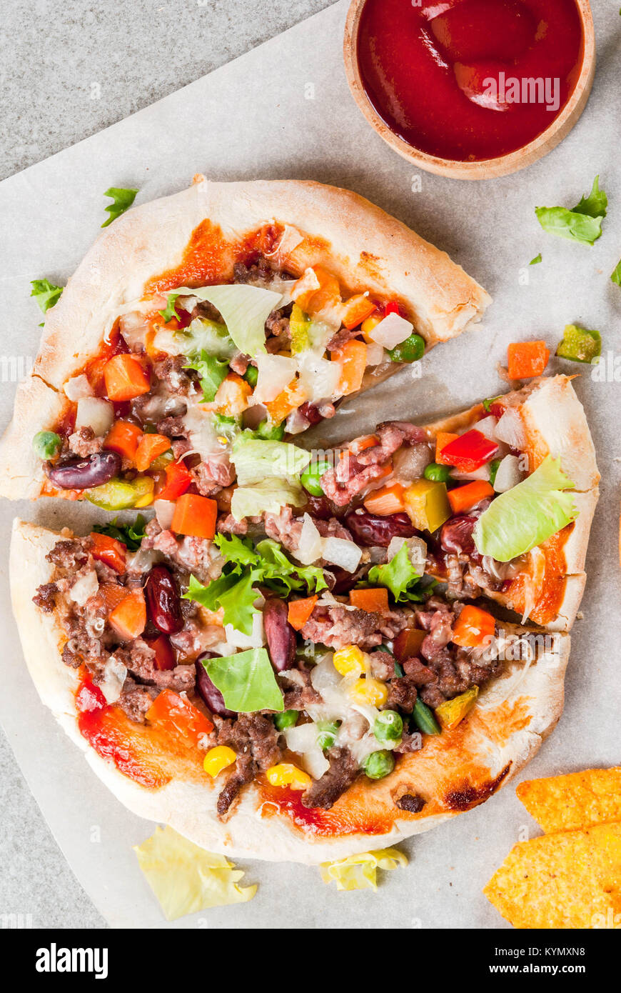 Homemade Mexican Taco PIzza with Nachos chips, beans, fresh vegetables, beef meat, copy space