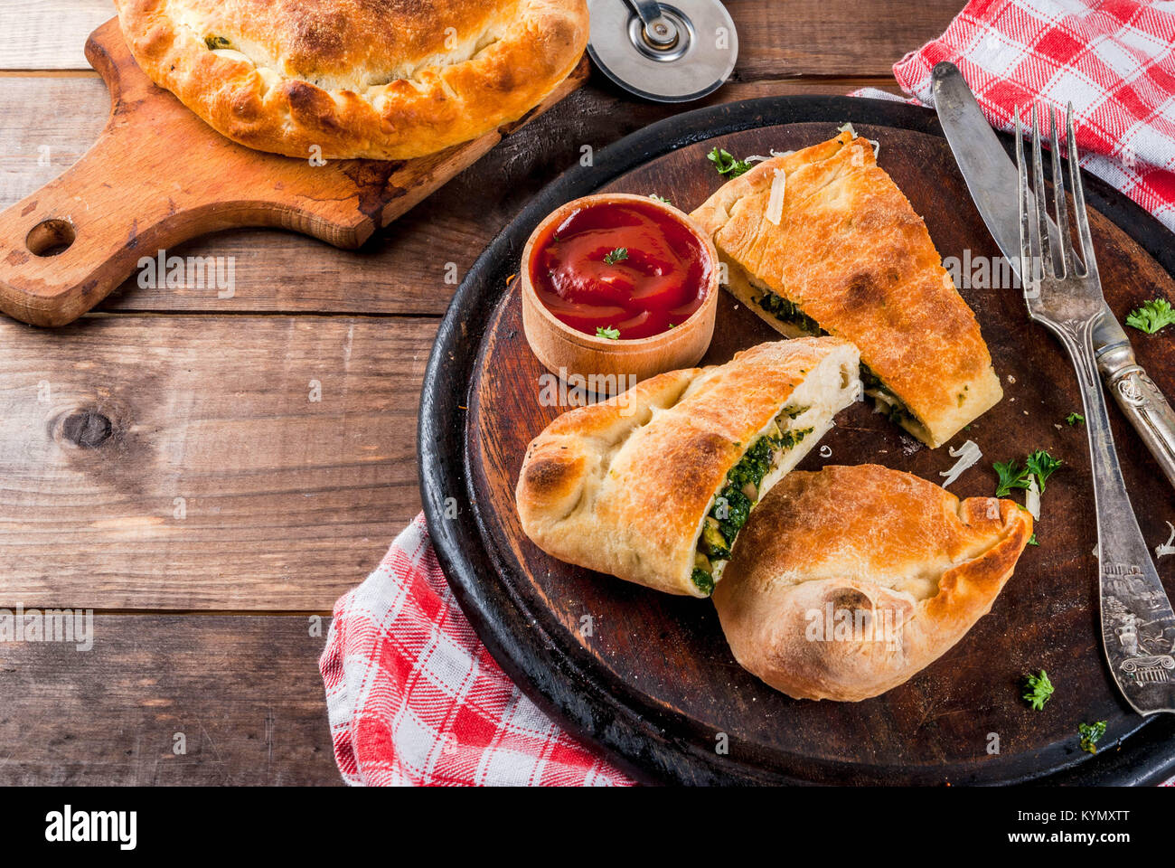 Italian food, closed pizza calzone with Spinach and Cheese, wooden