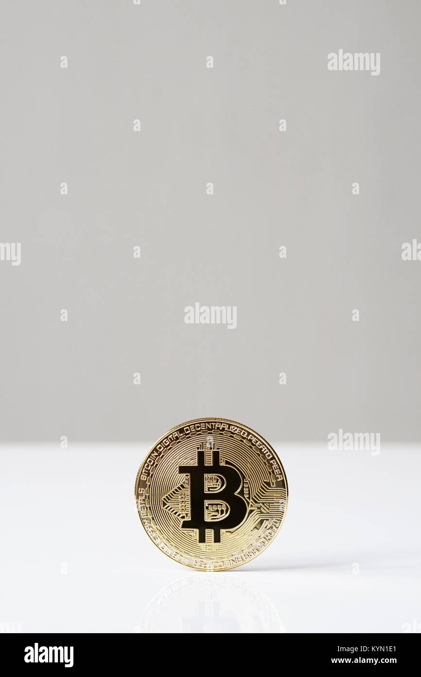 bitcoin cryptocurrency physical coin standing upright on desk Stock Photo