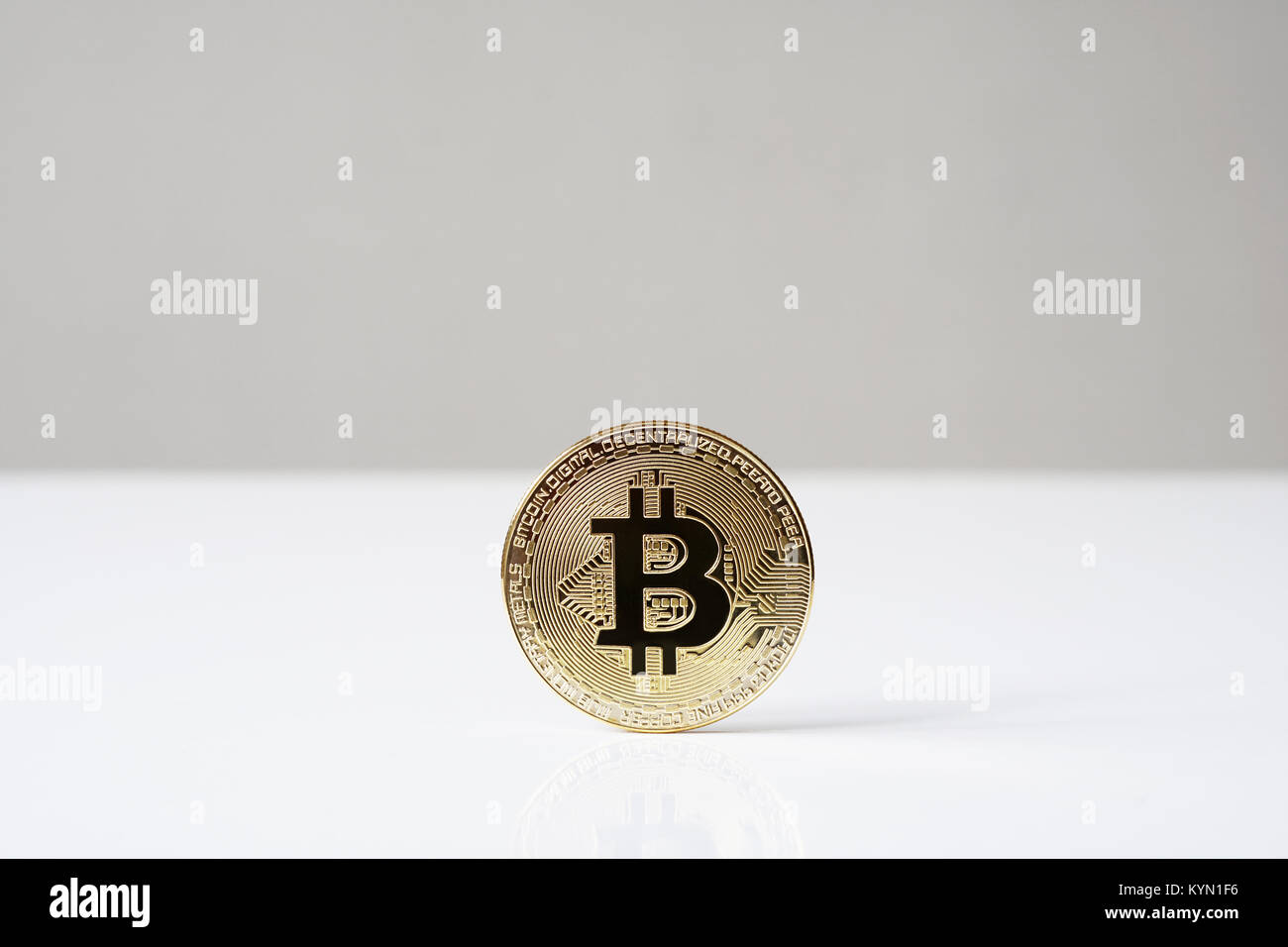 bitcoin cryptocurrency physical coin standing upright on desk Stock Photo