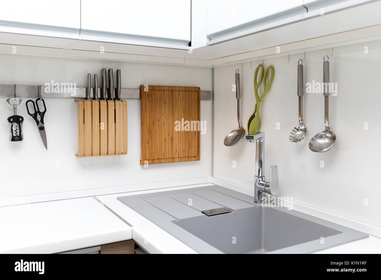 white glossy kitchen interior design with hanging utensils Stock Photo