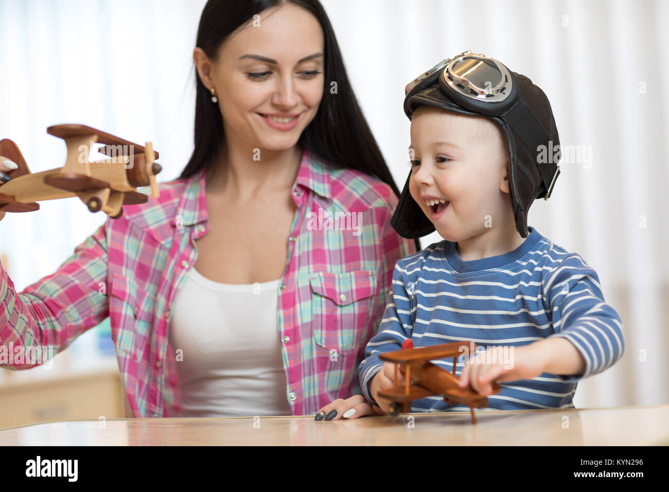 Mother and child son are playing with wooden planes. Stock Photo