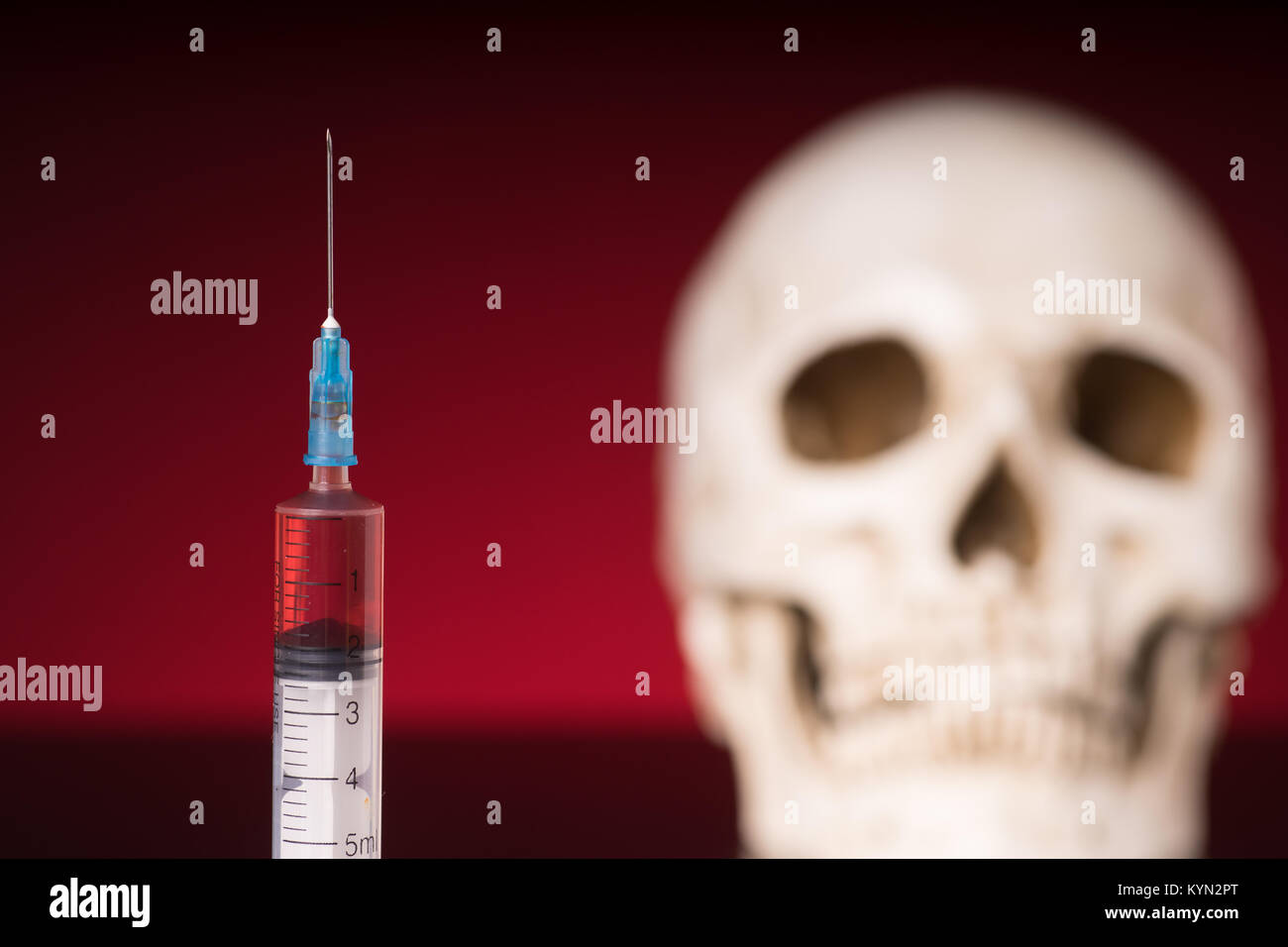 Blurry Skull and syringe, isolated on black red background Stock Photo