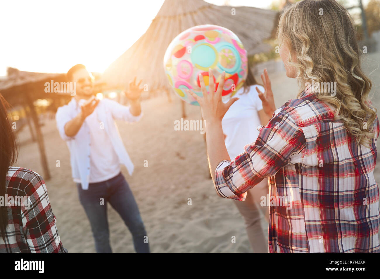 Group of young cheerful friends playing with ball Stock Photo