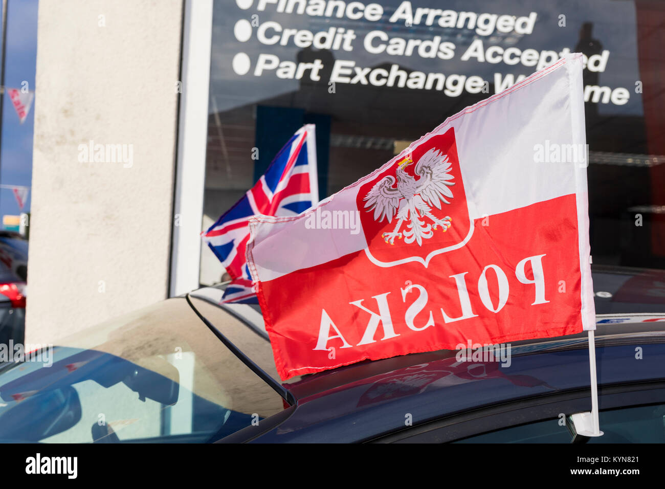 Polish flag with the word 'polska' written on it in reverse and a Union Jack flag in the background Stock Photo
