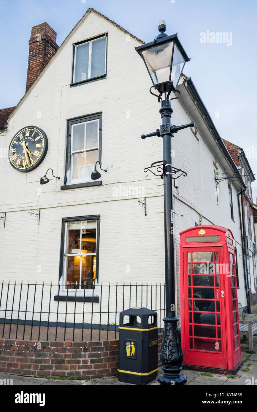 Building with white facade and an old red British telephone booth in the  quaint Hampshire village of Wickham, Hampshire, England, UK Stock Photo