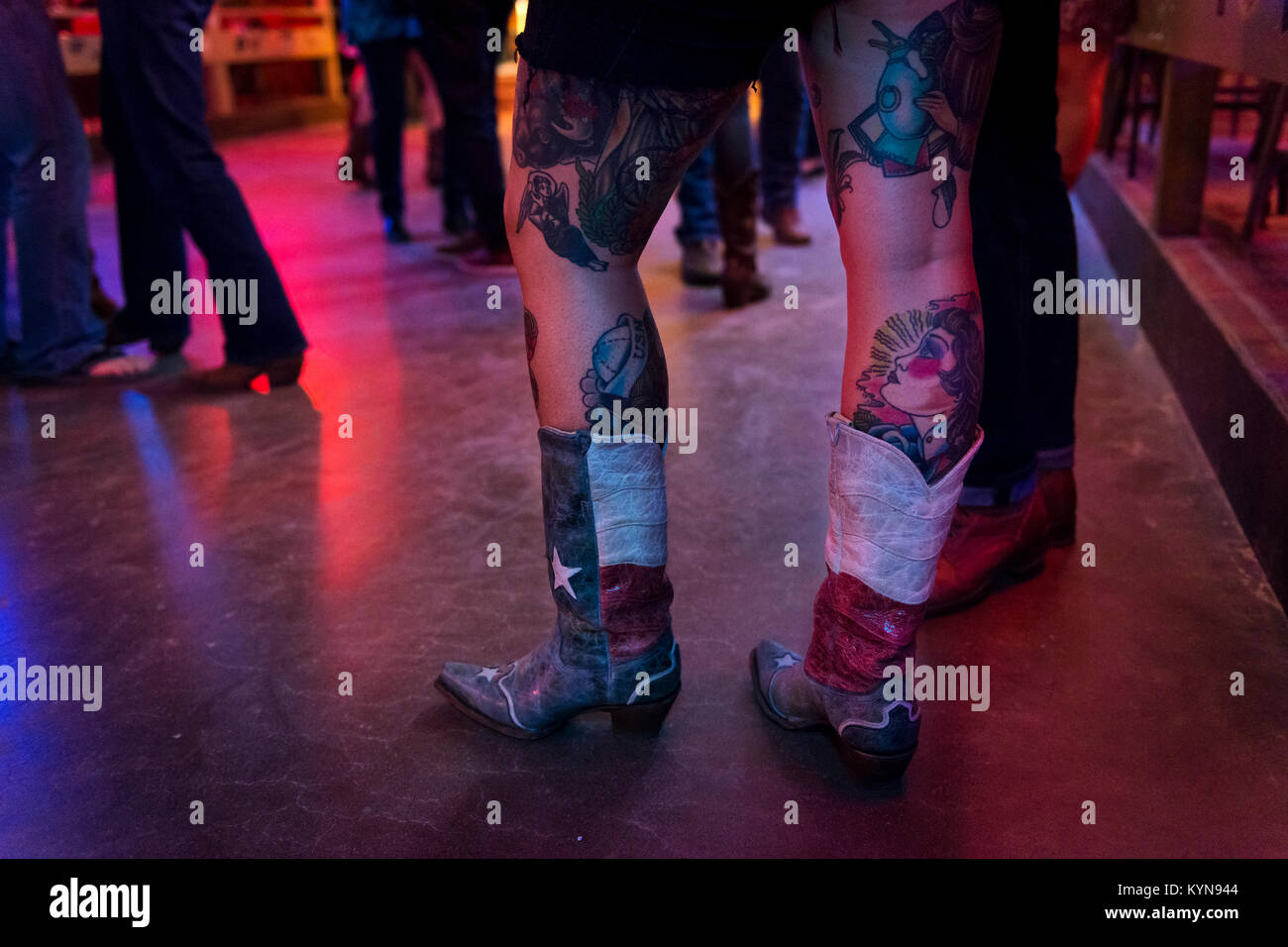 Austin, Texas - June 13, 2014: Detail of the boots and tattoed legs of a young woman in the Broken Spoke dance hall in Austin, Texas, USA Stock Photo