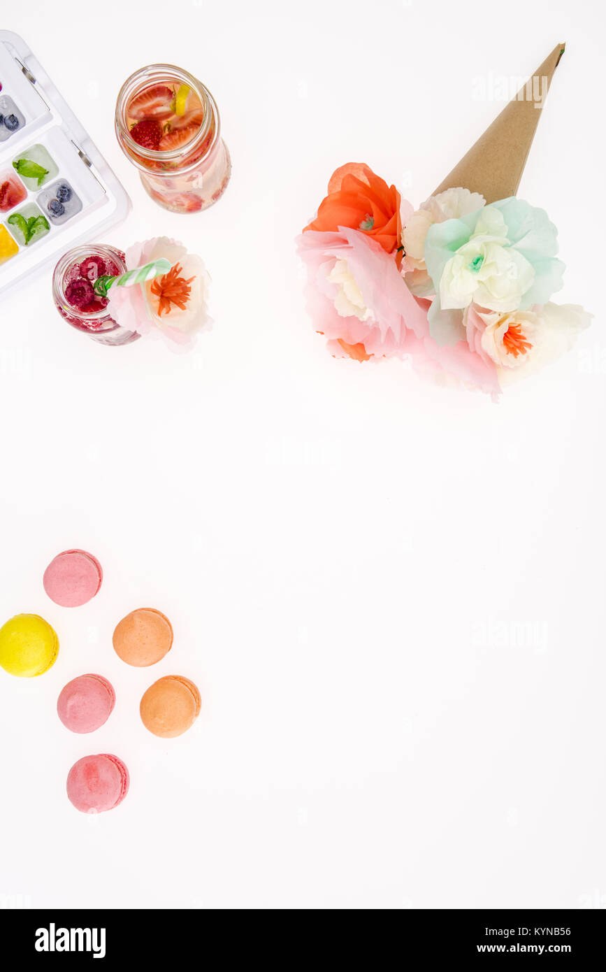 top view of decorative flowers with macaroons and fruity cocktails isolated on white Stock Photo
