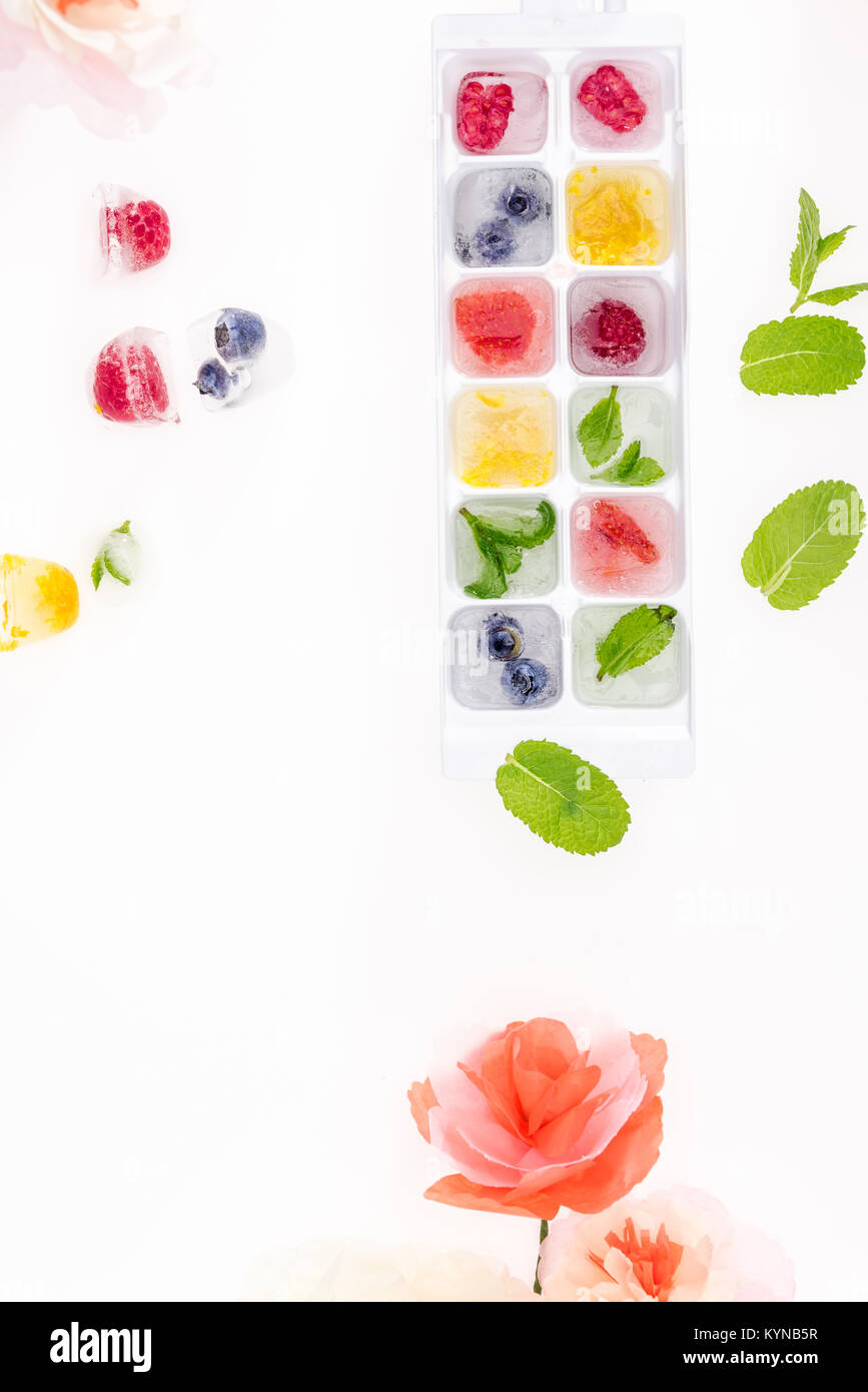 top view of berries and fruits in ice cubes with flowers isolated ob white Stock Photo