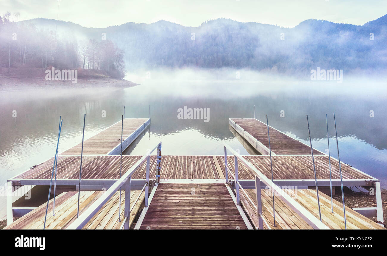 Floating docks on the Kruth Lake during a misty afternoon of winter, Vosges, France Stock Photo