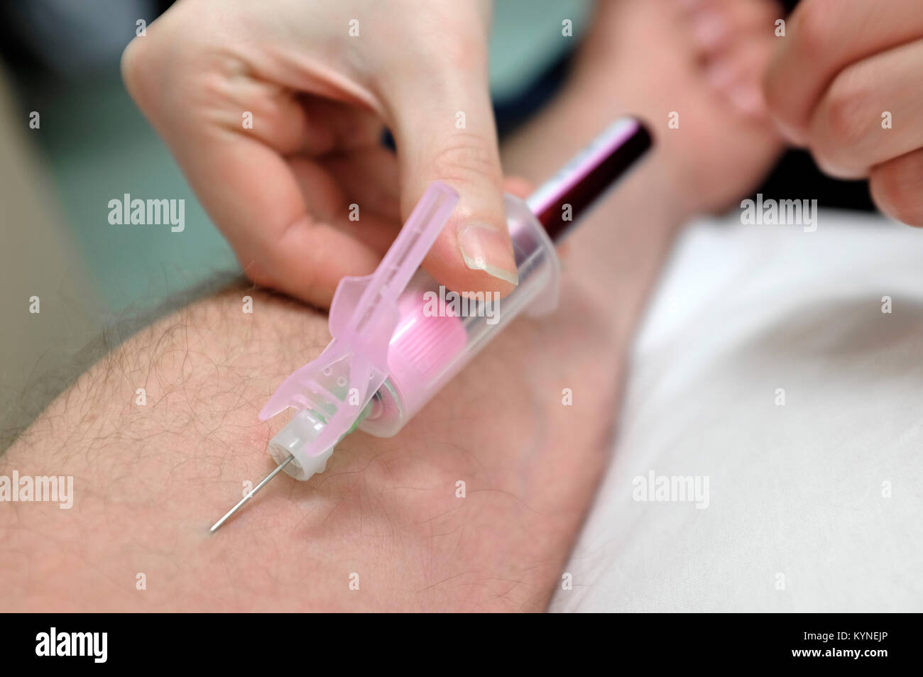 taking blood sample from male arm Stock Photo