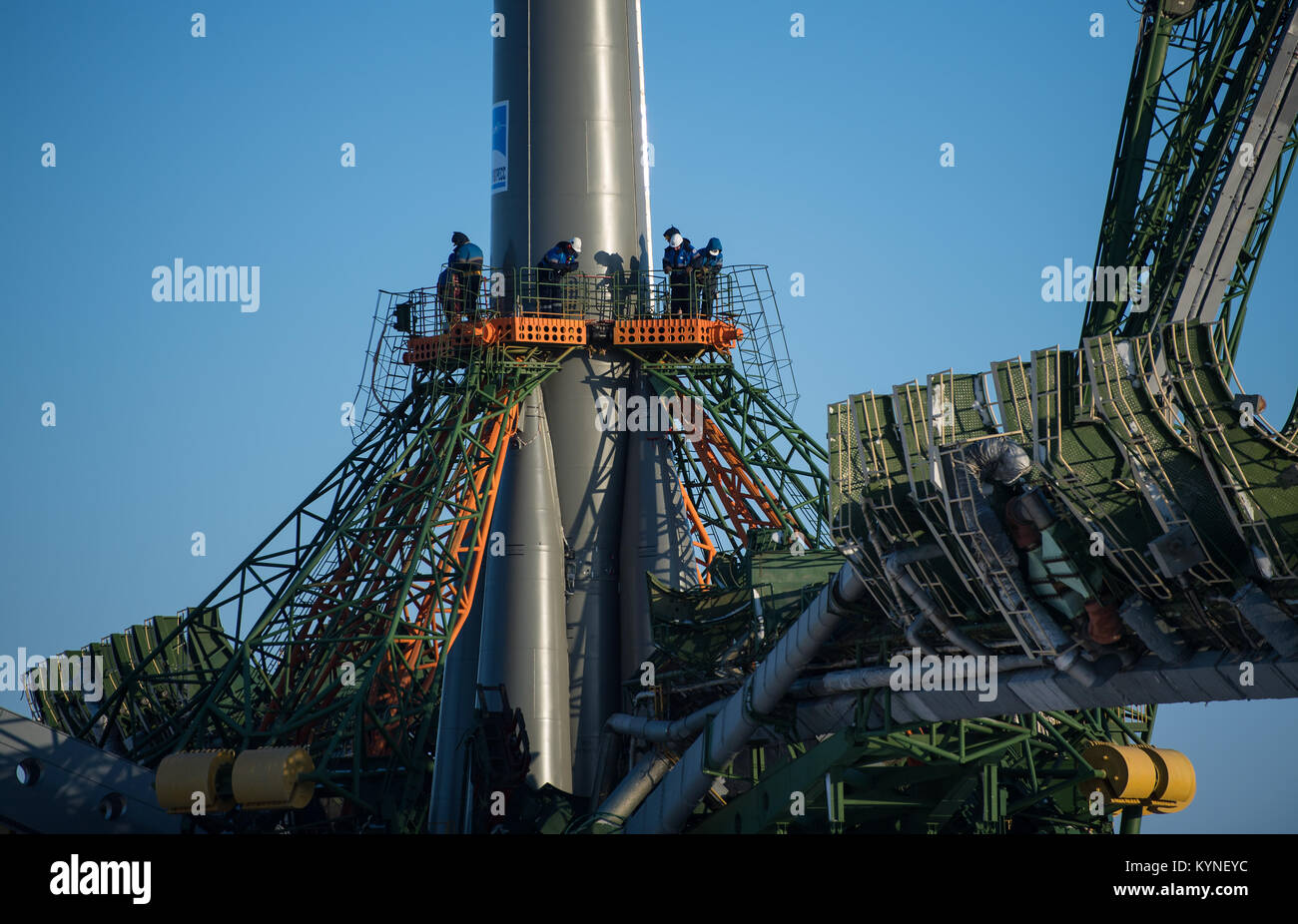 Workers are seen on a gantry as the service structure arms are raised around the Soyuz rocket, Friday, Dec. 15, 2017 at the Baikonur Cosmodrome in Kazakhstan. Expedition 54 Soyuz Commander Anton Shkaplerov of Roscosmos, flight engineer Scott Tingle of NASA, and flight engineer Norishige Kanai of Japan Aerospace Exploration Agency (JAXA) are scheduled to launch at 2:21 a.m. Eastern Time (1:21 p.m. Baikonur time) on Dec. 17 and will spend the next five months living and working aboard the International Space Station.  Photo Credit: (NASA/Joel Kowsky) Stock Photo