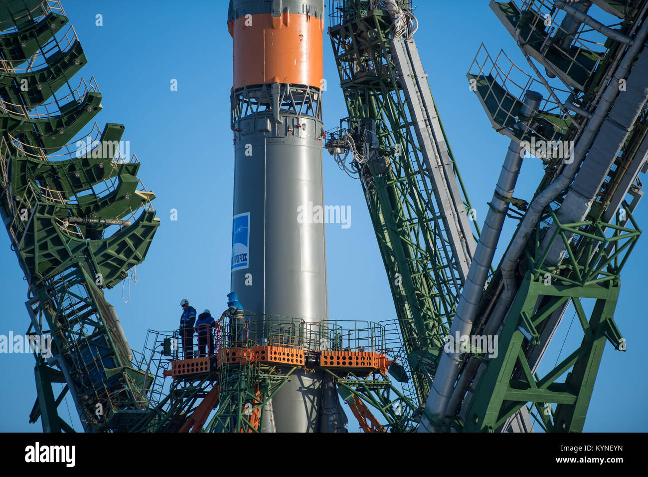 Workers are seen on a gantry as the service structure arms are raised around the Soyuz rocket, Friday, Dec. 15, 2017 at the Baikonur Cosmodrome in Kazakhstan. Expedition 54 Soyuz Commander Anton Shkaplerov of Roscosmos, flight engineer Scott Tingle of NASA, and flight engineer Norishige Kanai of Japan Aerospace Exploration Agency (JAXA) are scheduled to launch at 2:21 a.m. Eastern Time (1:21 p.m. Baikonur time) on Dec. 17 and will spend the next five months living and working aboard the International Space Station.  Photo Credit: (NASA/Joel Kowsky) Stock Photo
