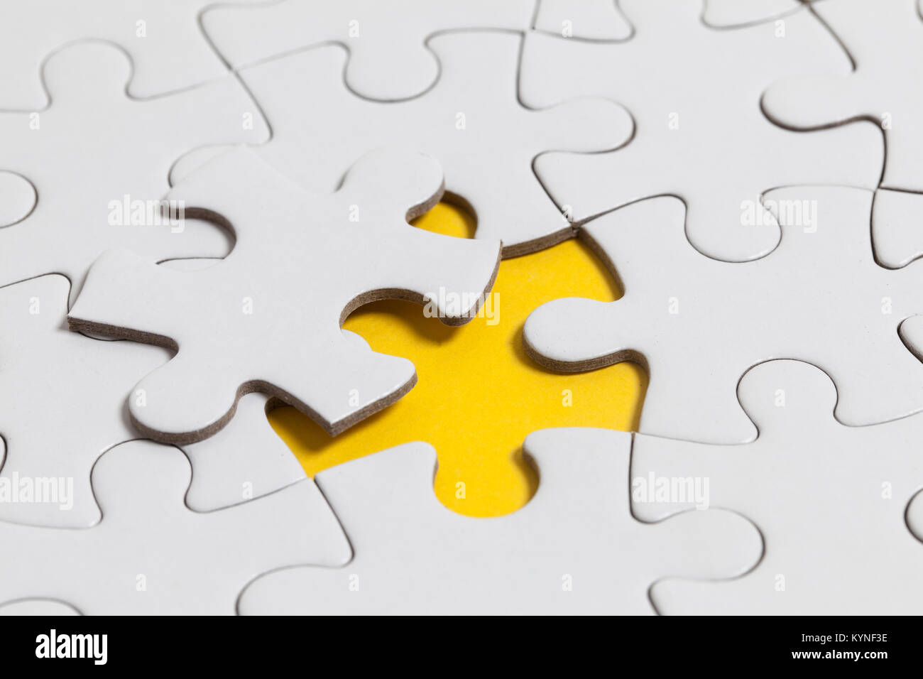 White jigsaw puzzle pieces on a yellow background. Business solution concept Stock Photo