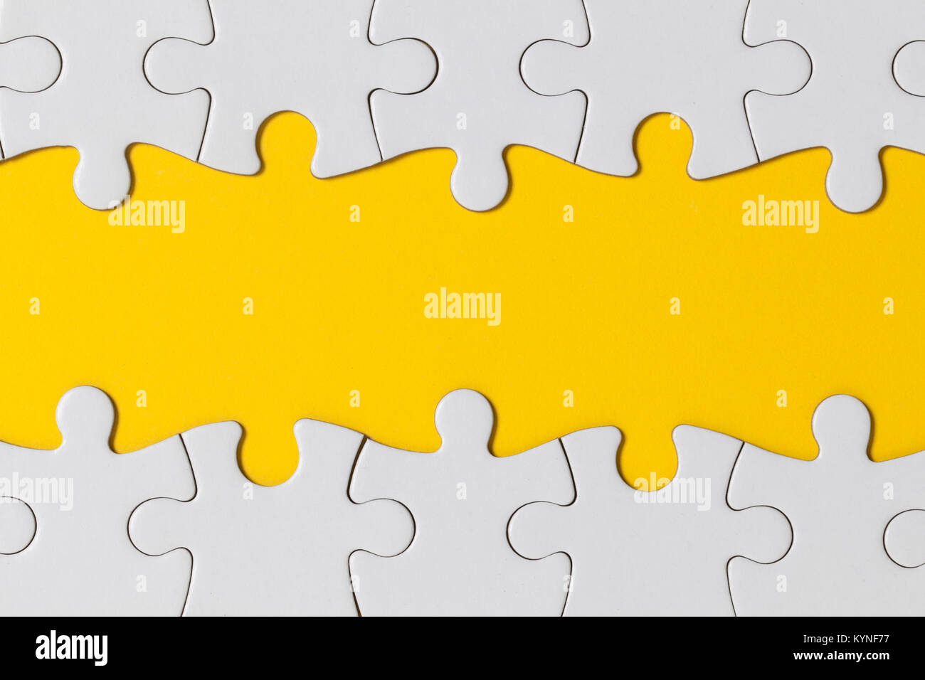 White jigsaw puzzle pieces on a yellow background. Business solution concept Stock Photo