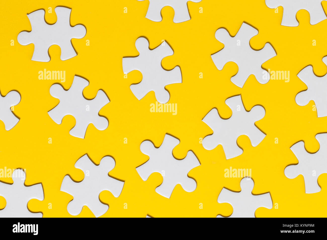 White jigsaw puzzle pieces on a yellow background. Business solution concept Stock Photo