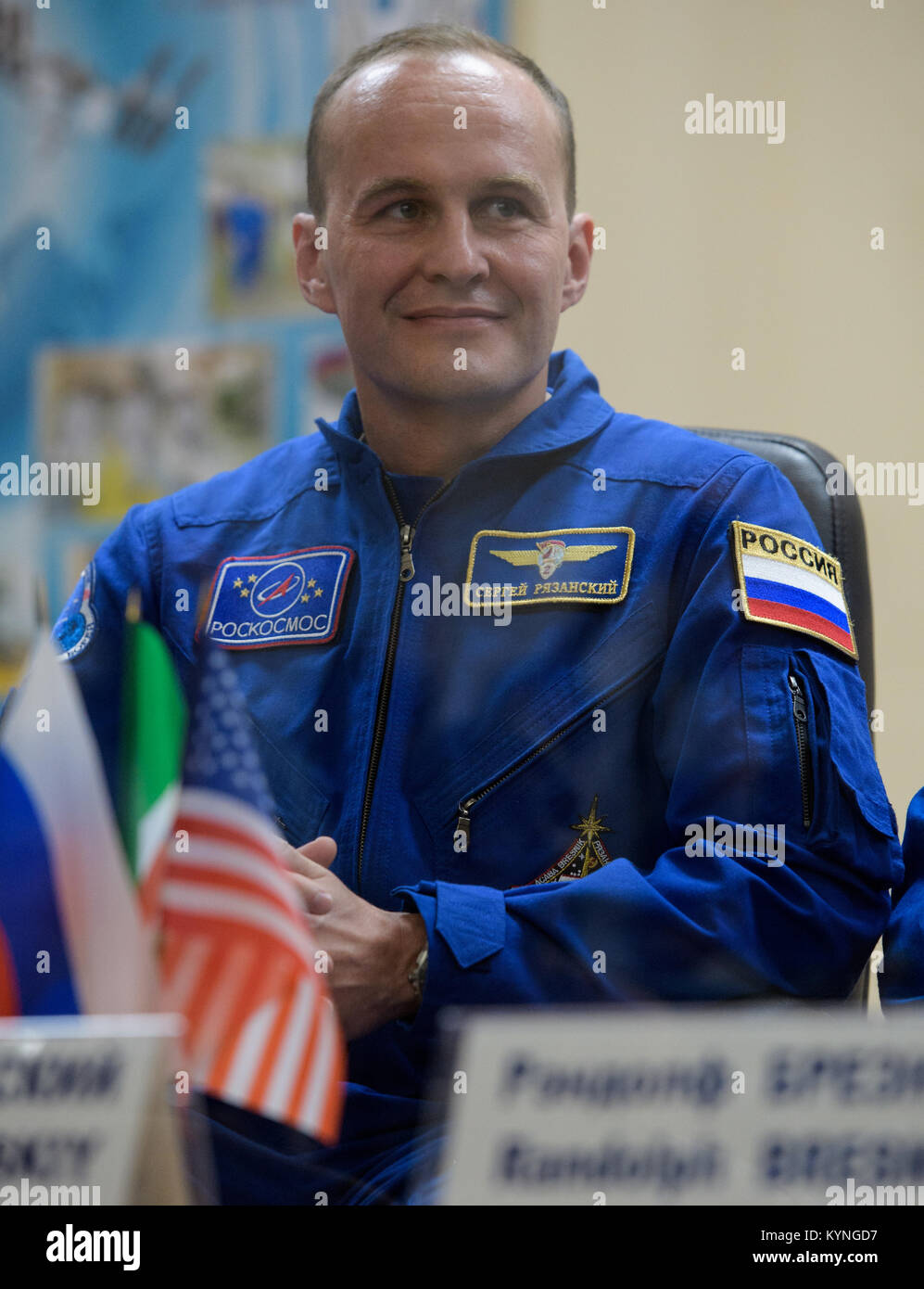 Expedition 52 flight engineer Sergei Ryazanskiy of Roscosmos is seen in quarantine behind glass during a crew press conference Thursday, July 27, 2017 at the Cosmonaut Hotel in Baikonur, Kazakhstan.  Ryazanskiy and fellow Expedition 52 crew members flight engineer Randy Bresnik of NASA and flight engineer Paolo Nespoli of ESA (European Space Agency) are scheduled to launch to the International Space Station aboard the Soyuz spacecraft from the Baikonur Cosmodrome on July 28.  Photo Credit: (NASA/Joel Kowsky) Stock Photo