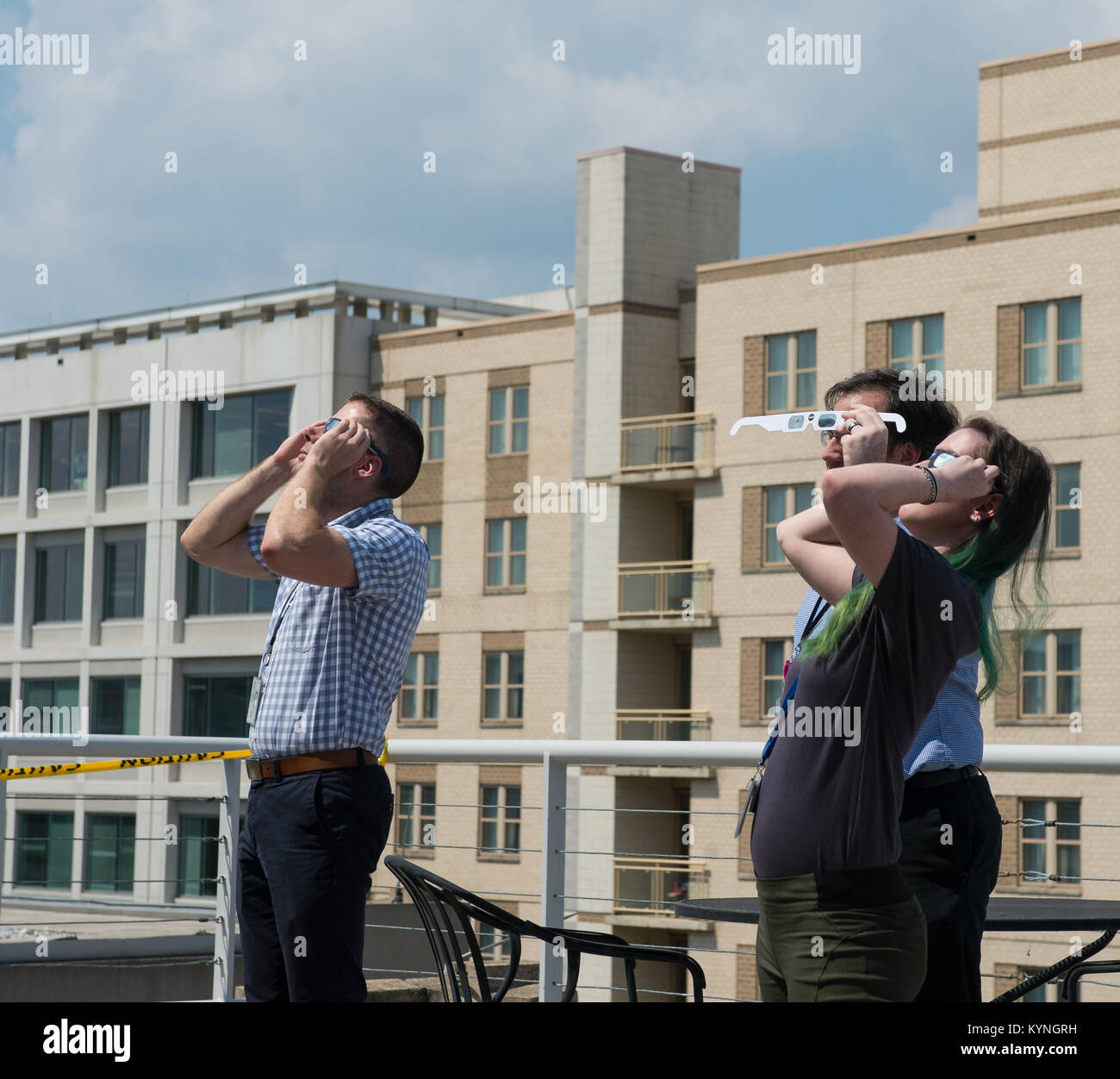 NASA employees and contractors use protective glasses to view a partial solar eclipse from NASA Headquarters Tuesday, Aug. 22, 2017 in Washington. A total solar eclipse swept across a narrow portion of the contiguous United States from Lincoln Beach, Oregon to Charleston, South Carolina. A partial solar eclipse was visible across the entire North American continent along with parts of South America, Africa, and Europe.  Photo Credit: (NASA/Gwen Pitman) Stock Photo
