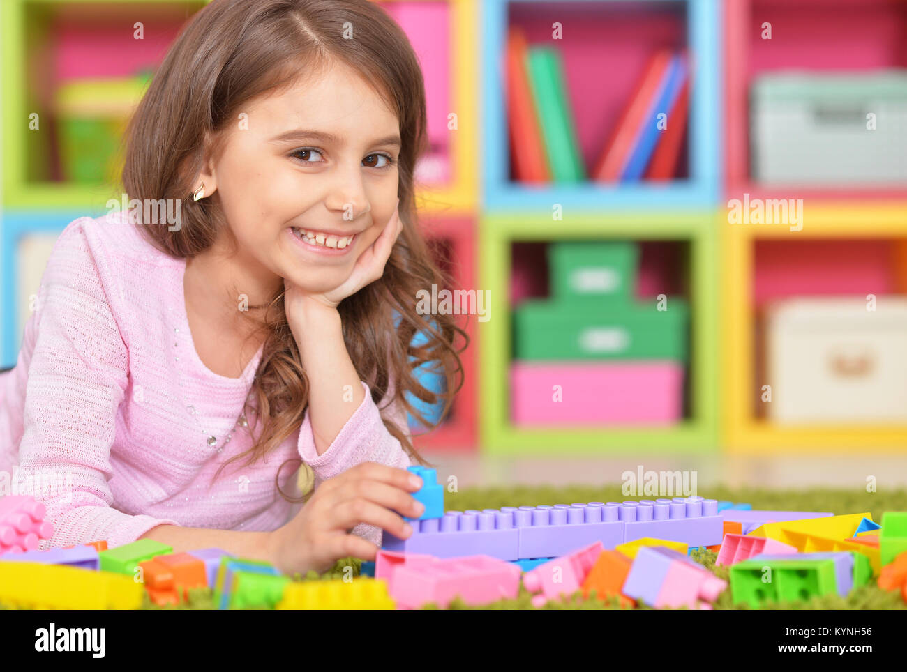 Cute girl playing with plastic blocks Stock Photo - Alamy