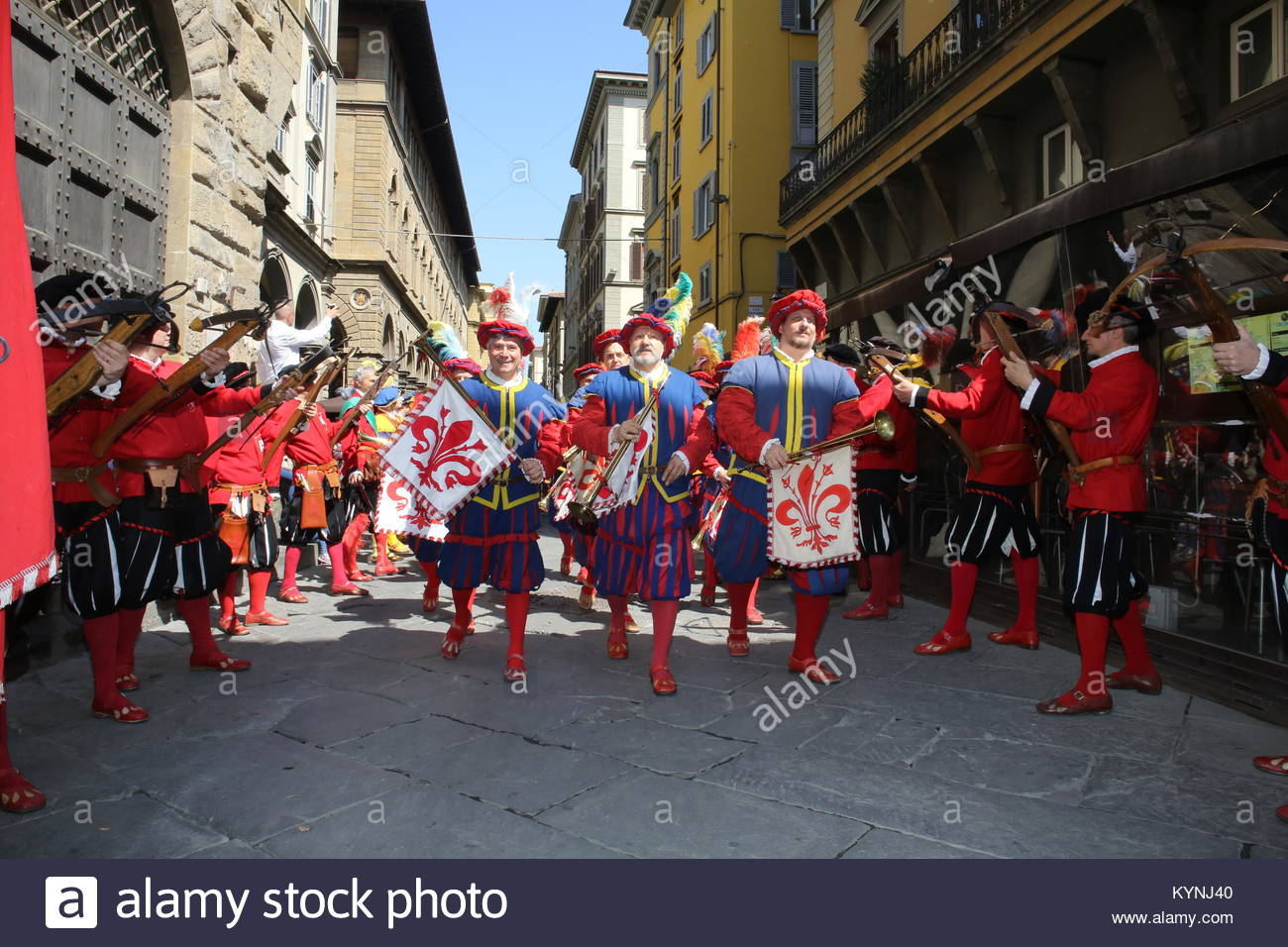Participants in The Explosion of the Cart festival march through Florence in bright costumes at the end of the day. Stock Photo
