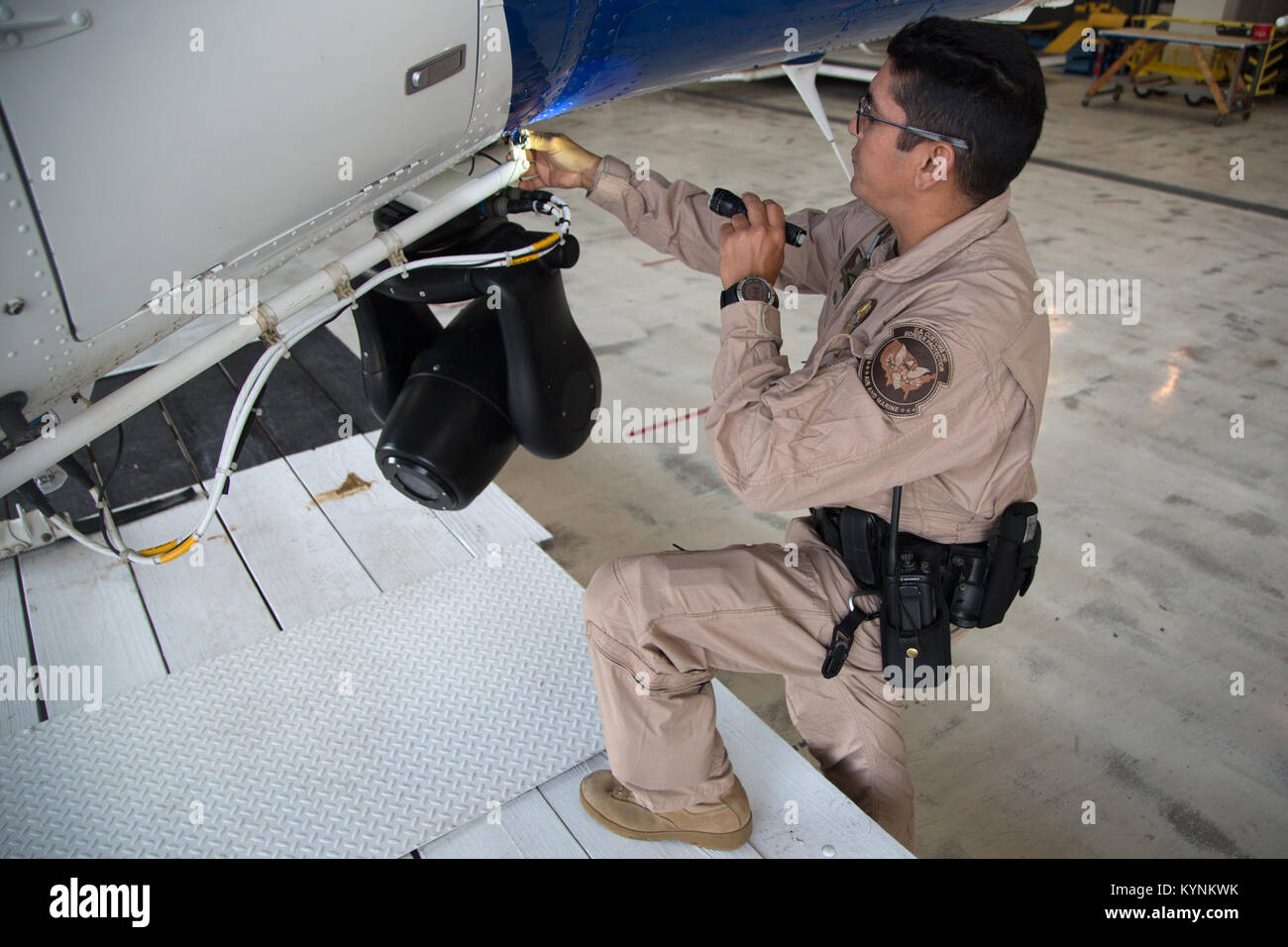 A U.S. Customs and Border Protection, Air and Marine Operations pilot operating out of Laredo, Texas conducts a pre-inspection on a CBP helicopter in preparation of a flight.  Photographer: Donna Burton Stock Photo