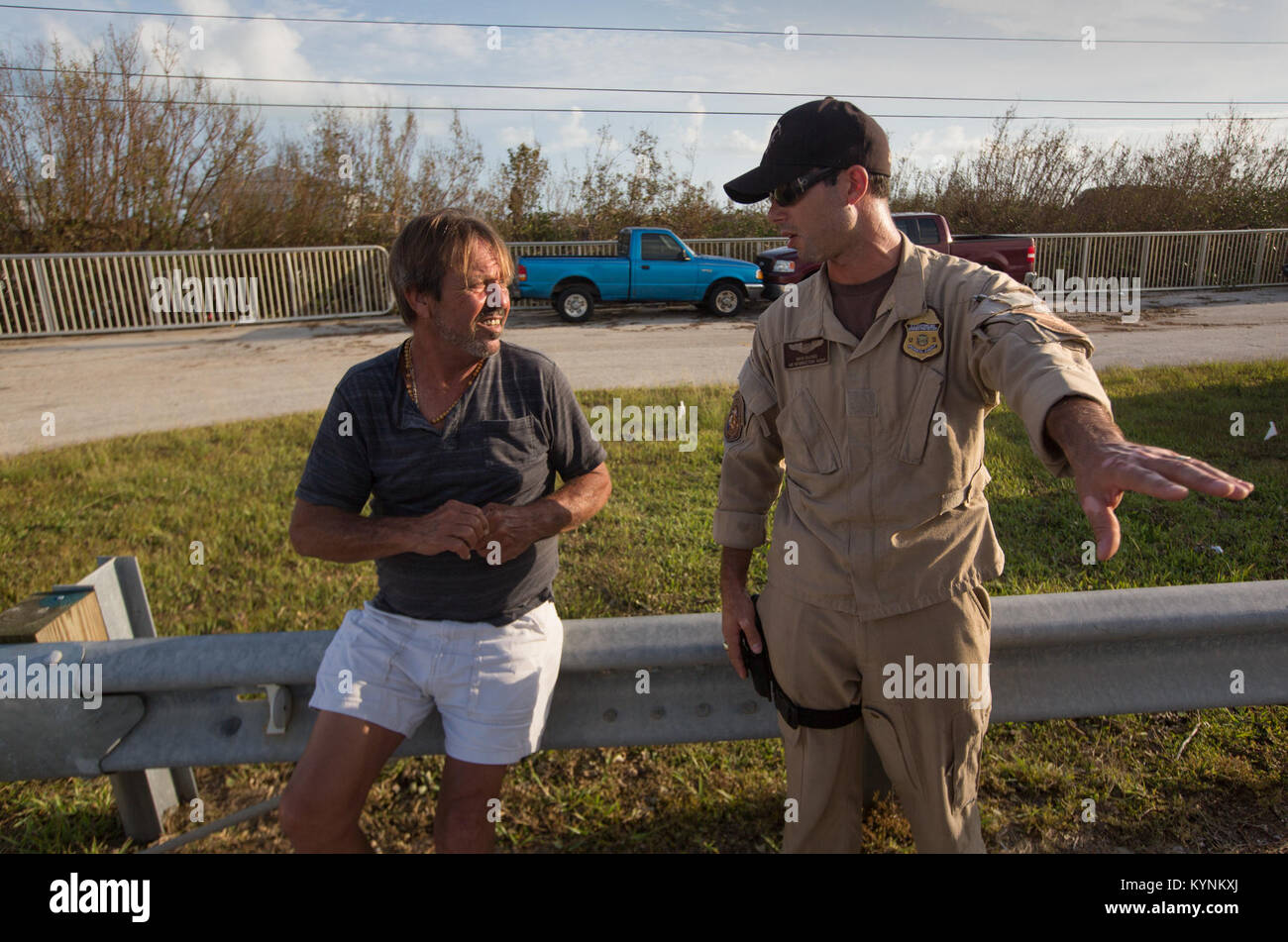 U.S. Customs and Border Protection Air and Marine Operations Air Interdiction Agent David Backes talks with resident George Ramos who weathered through Hurricane Irma in the Florida Keys. Agent Backes and his crew flew a broadcast team from The Weather Channel into the Cudjoe Key to survey the damage on a Black Hawk flight from Homestead, Fla., September 12, 2017. U.S. Customs and Border Protection photo by Glenn Fawcett Stock Photo