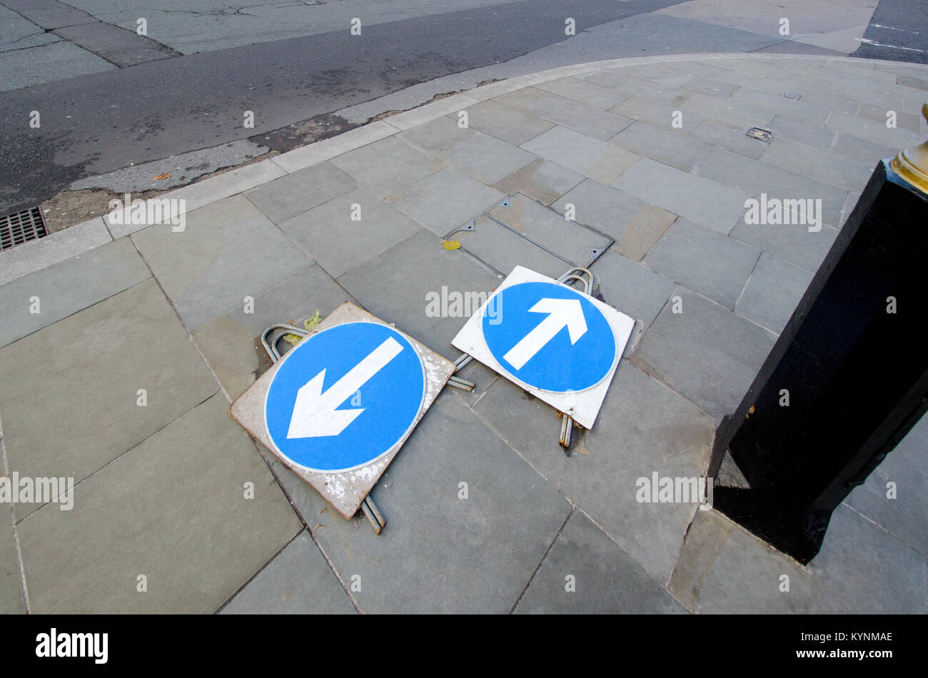 London, England, UK. Traffic arrow signs lying flat on the pavement pointing in different directions Stock Photo