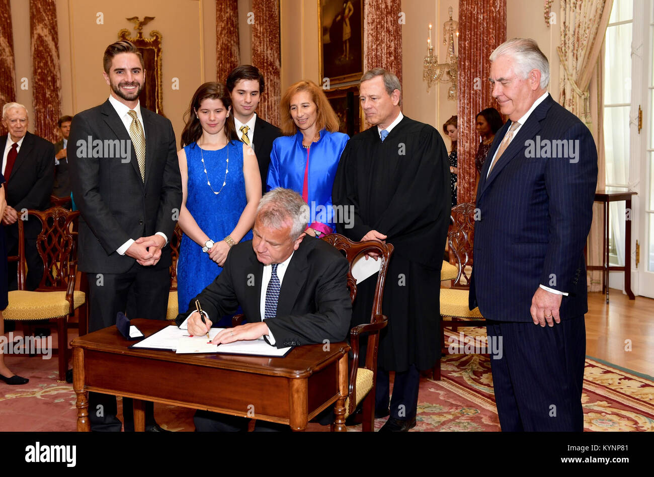 With his family, U.S. Chief Justice John G. Roberts Jr., and U.S. Secretary of State Rex Tillerson looking on, John Sullivan signs his appointment papers to become the new Deputy Secretary of State at a ceremony at the U.S. Department of State in Washington, D.C., on June 9, 2017. Deputy Secretary Sullivan Signs His Appointment Papers at his Swearing-in 34394113583 o Stock Photo