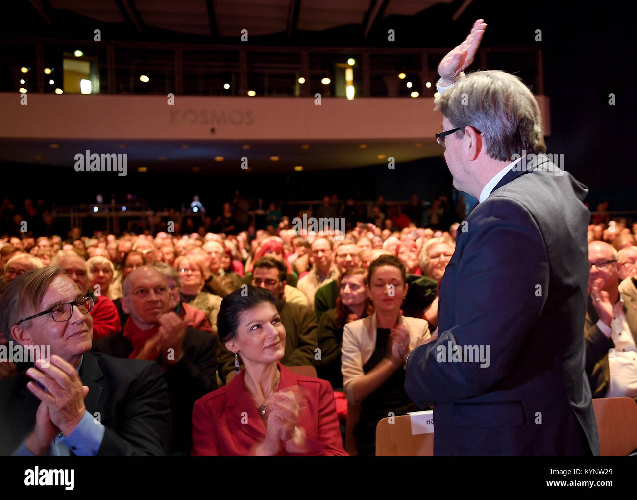 Berlin, Germany. 14th Jan, 2018. The faction leaders of the party 'die Linke', Dietmar Bartsch (L) and Sahra Wagenknecht applaud during the arrival of the French leftist politician Jean-Luc Melenchon (R) at the annual kick-off event 'Aufbruch für soziale Sicherheit' (lit. 'Takeoff for social security') at the Kosmos facility in Berlin, Germany, 14 January 2018. Credit: Britta Pedersen/dpa/Alamy Live News Stock Photo