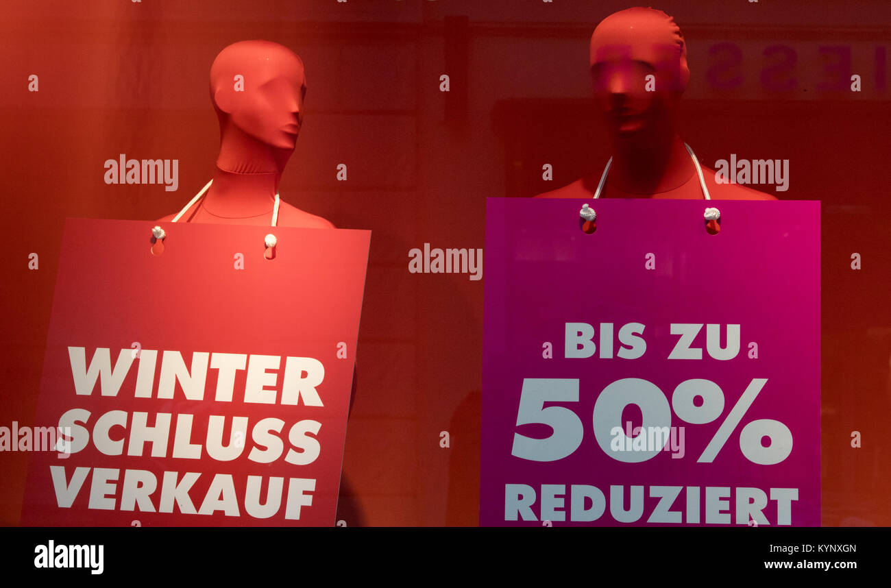 Dressed up mannequins carry signs reading 'Winterschlussverkauf' (lit. winter sales) and 'Bis zu 50% reduziert' (lit. reduced by up to 50%) at a department store in Potsdam, Germany, 15 January 2018. Photo: Ralf Hirschberger/dpa-Zentralbild/dpa Stock Photo