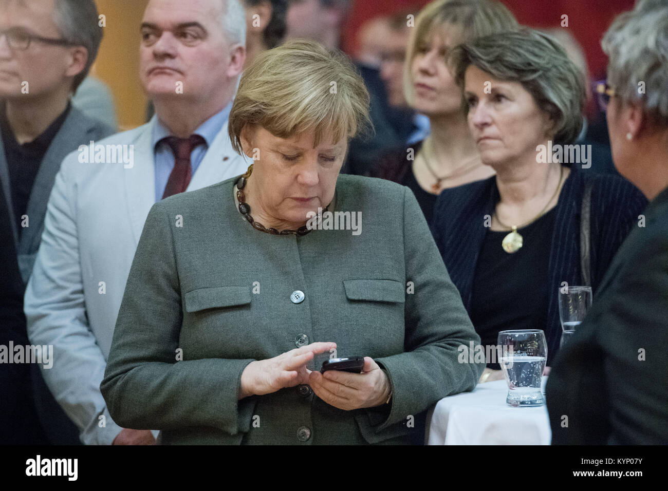 Trinwillershagen, Germany. 12th Jan, 2018. German Chancellor Angela Merkel (CDU) checks her telephone during the New Year's Reception of the state counsil of the district Vorpommern-Ruegen in Trinwillershagen, Germany, 12 January 2018. Merkel has been representing the electoral district Stralsund-Greifswald-Ruegen-Vorpommern since 1990 in the German Bundestag with a direct mandate. Credit: Stefan Sauer/dpa/Alamy Live News Stock Photo