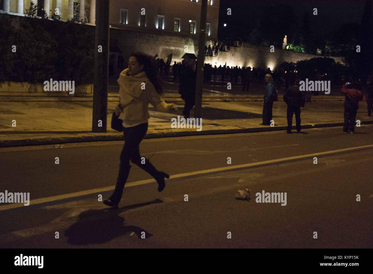 Athens, Greece. 15th Jan, 2018. A passer by woman runs away from clashes. Thousands took to the streets protesting over the multi-bill that is introduced for voting at the parliament, which contains further austerity measures including an amendment that will make it harder for workers to go on strike. Credit: Nikolas Georgiou/ZUMA Wire/Alamy Live News Stock Photo