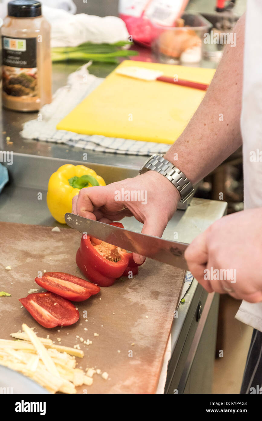 Food preparation - a chef preparing food in a restaurant kitchen. Stock Photo