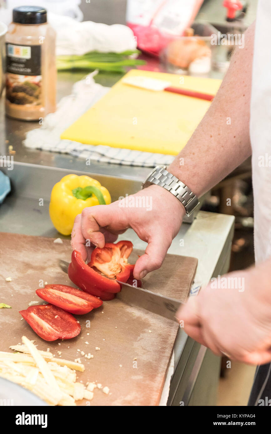 Food preparation - a chef preparing food in a restaurant kitchen. Stock Photo