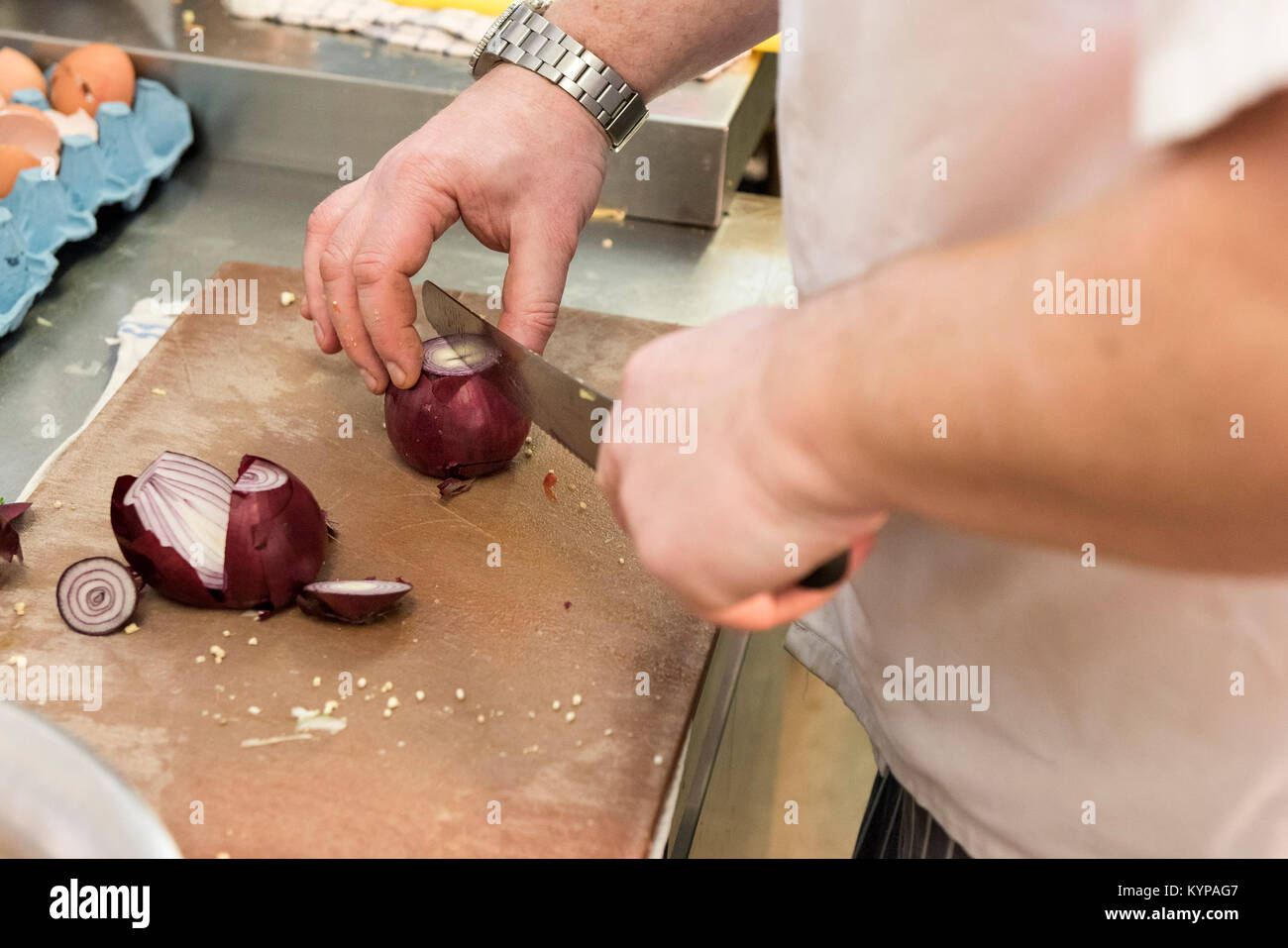 Food preparation - a chef preparing food in a restaurant kitchen. Stock Photo