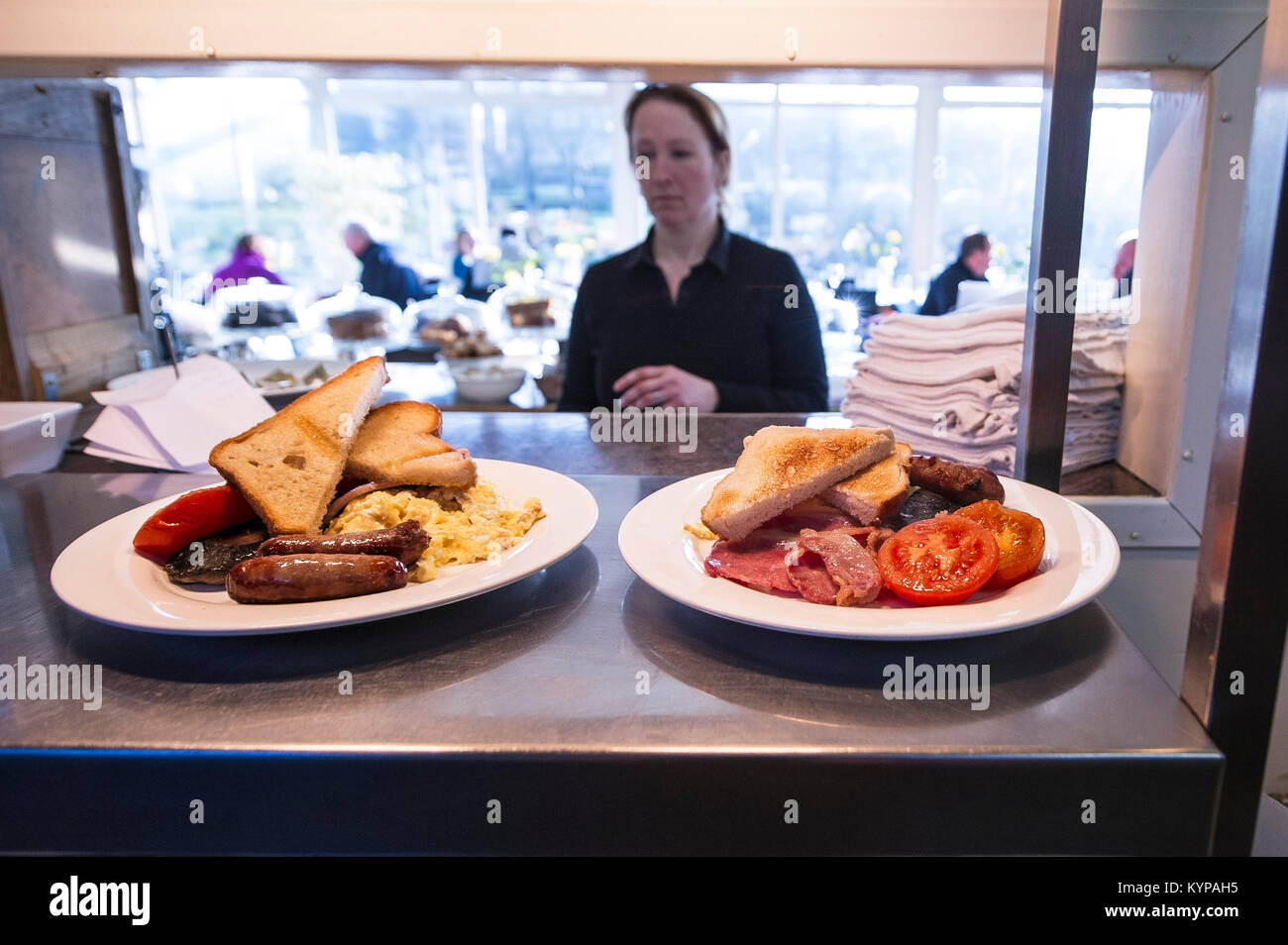 Food preparation - two full english breakfasts waiting at the pass in a restaurant. Stock Photo