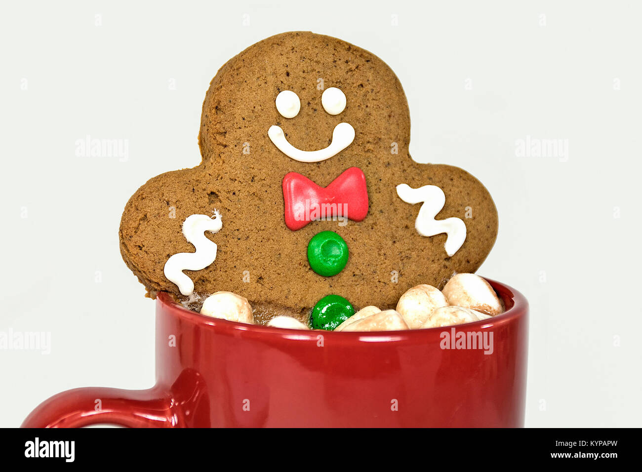smiling gingerbread man in hot cocoa drink with marshmallows in red mug Stock Photo