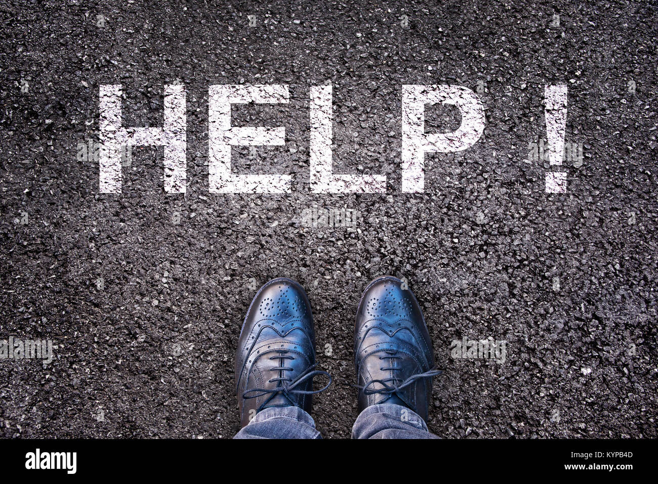 Word Help written on an asphalt road with legs and shoes Stock Photo