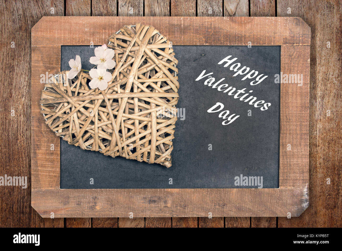 Valentine card, wooden heart with cherry tree flower and vintage wooden blackboard Stock Photo